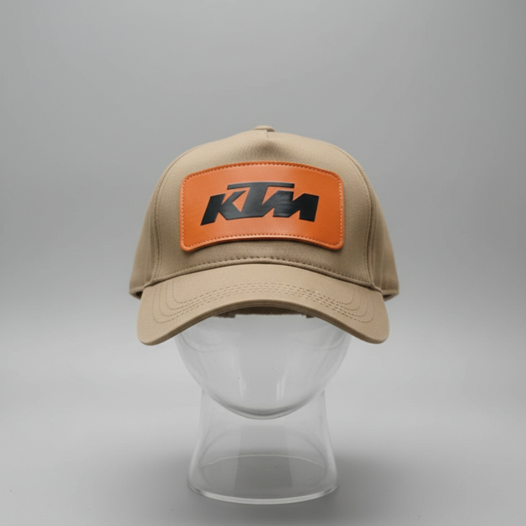 Beige cap with a rectangular orange patch and dark lettering at the front