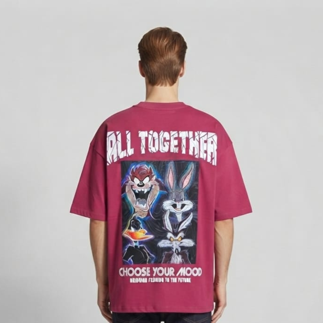 Pink t-shirt with a framed panel of neon coloured cartoon faces and arched white lettering above it