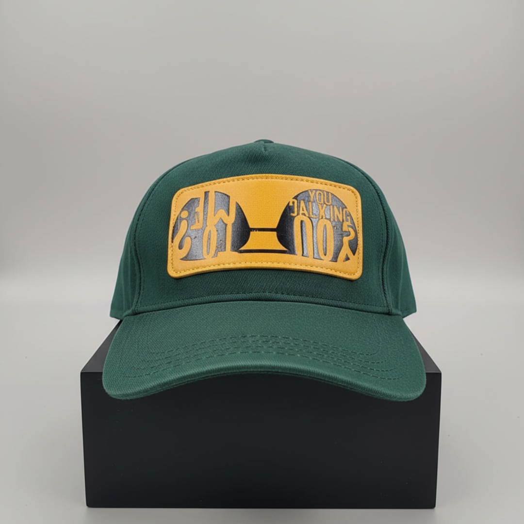Green cap with a wide yellow patch and grey lettering at the front