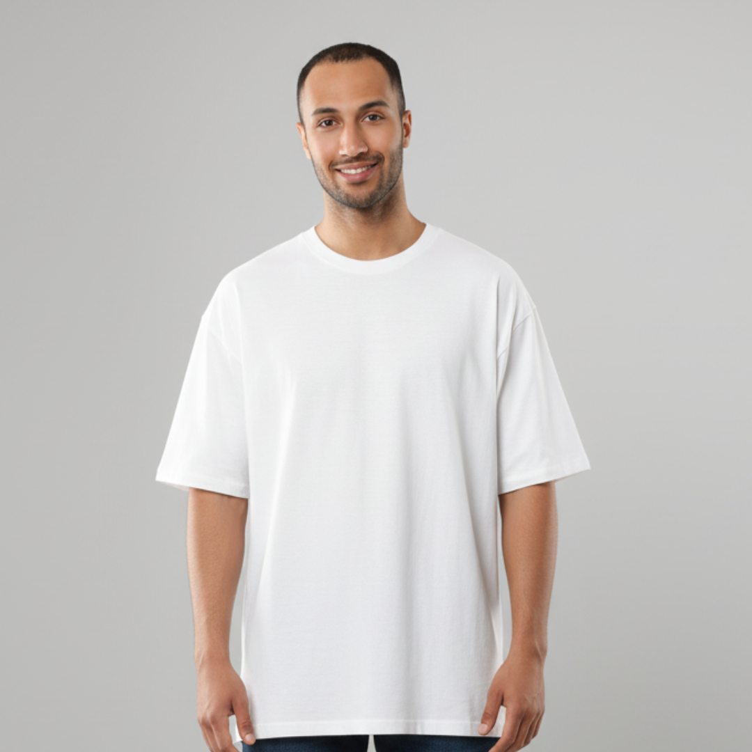 Smiling man in a very wide white tee with short sleeves and a round neck on a pale grey backdrop