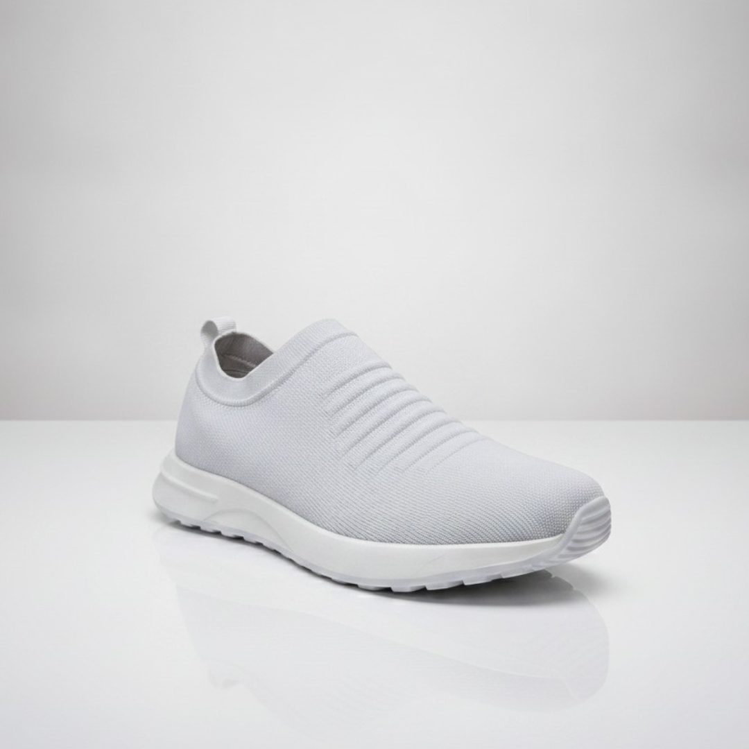 All white slip on sneaker with a ribbed side panel and a white sole, front angle